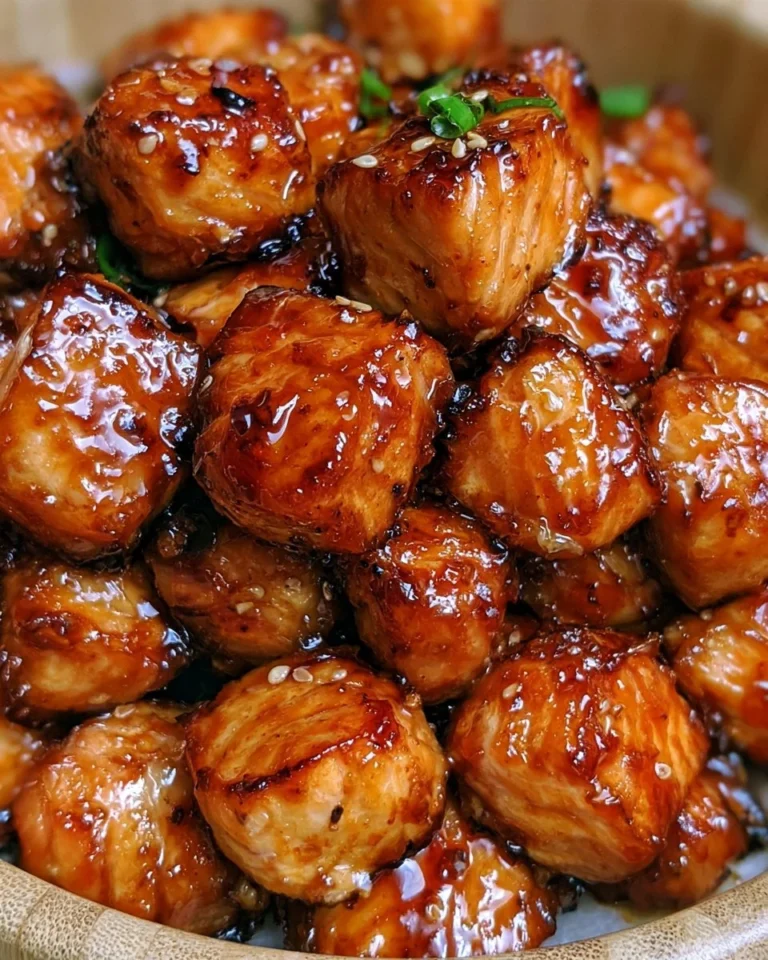 Crispy honey garlic salmon bites served on a plate, garnished with herbs.